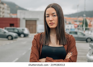 Portrait Of Serious Asian Girl Outdoors Looking At Camera