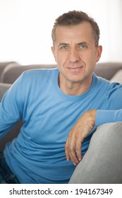 Portrait of serious and attractive mature man relaxing at home