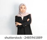 portrait of Serious beautiful young Asian muslim business woman wearing hijab and black suit,looking at the camera and crossing his arms over her chest.