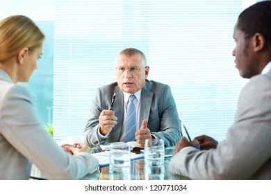 Portrait Of Serious Boss Talking To His Employees