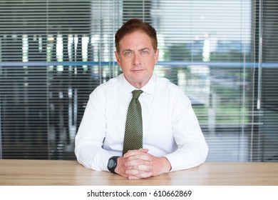 Portrait of serious businessman sitting in office - Powered by Shutterstock