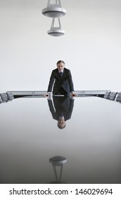 Portrait Of A Serious Businessman Standing At Conference Table