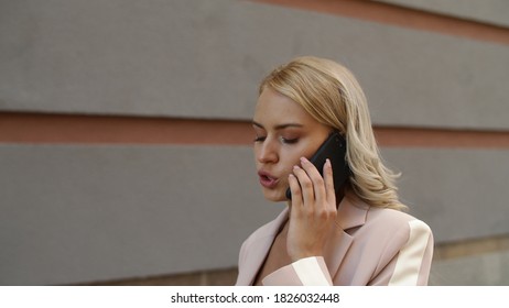 Portrait Serious Businesswoman Talking Phone Outdoor. Blonde Woman Talking About Business On Smartphone At Street. Sexy Woman Speaking On Mobile Phone Outdoor. Female Manager Call Cellphone Outside