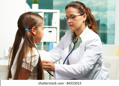 Portrait Of Serious Clinician In Eyeglasses Examining Youthful Patient With Stethoscope