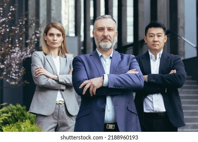 Portrait Of Serious Diverse Business Team, Employees With Boss Together Looking At Camera Seriously And Thoughtfully, Group Of Business People Outside Office In Business Suits