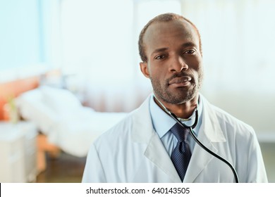 Portrait Of Serious Doctor With Stethoscope Standing In Hospital Chamber