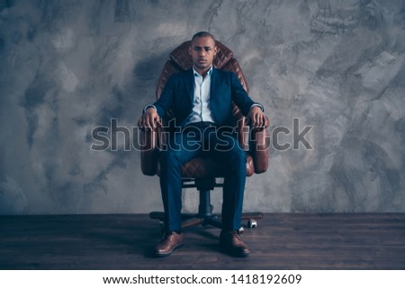 Portrait serious focused chairman entrepreneur manager ceo boss short hair bald sit brown furniture dream dreamy leader leadership dressed fashionable blazers trousers shoes isolated dark background
