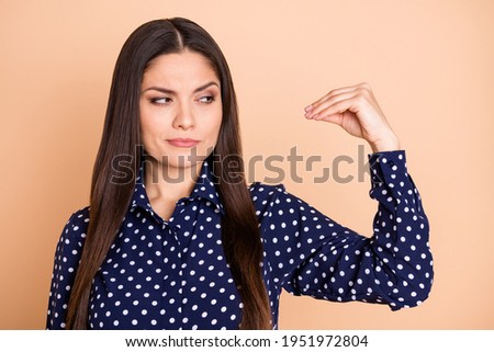 Portrait of serious lady hesitate look distrust arm fingers show blah symbol isolated on beige color background