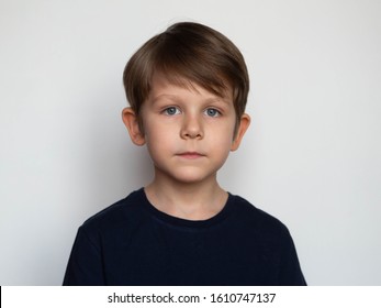 Portrait Of A Serious Little Boy On A White Background