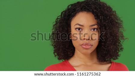 Portrait of serious looking black woman staring at camera on green screen