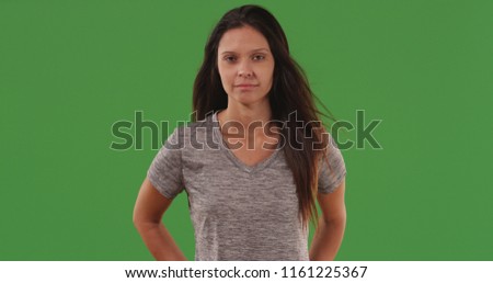 Portrait of serious looking female posing for camera on green screen