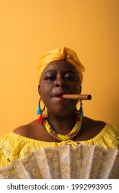 Portrait Of Serious Middle Aged African American Woman Smoking Cigar On Yellow