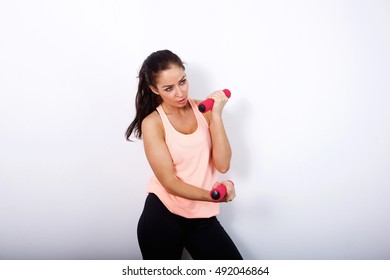 Portrait Of Serious Older Woman Lifting Weights Against White Background