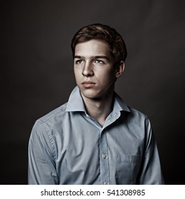 Portrait Of Serious, Sad, Thoughtful Handsome Young Man On Gray Background, Teenager In Studio, Close Up