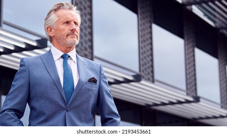 Portrait Of Serious Senior Businessman CEO Chairman Standing Outside Modern Office Building