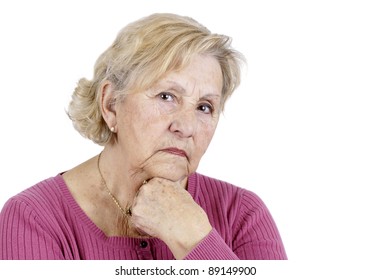 Portrait Of A Serious Senior Woman Holding Her Chin Looking At The Camera, Isolated On White.