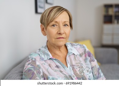 Portrait Of Serious Senior Woman Sitting On Sofa