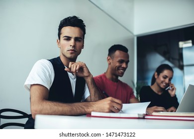 Portrait Of Serious Spanish Man Looking At Camera During Brainstorming Meeting With Entrepreneurs Colleagues, Skilled Man And Woman Working At Desktop, Concept Of Organisation And Planning Time