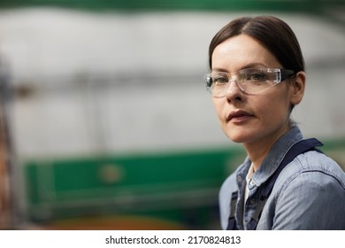 Portrait Of Serious Tough Middle-aged Woman In Protective Eyewear Working In Metalworking Industry