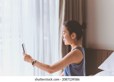 Portrait Of Serious Woman Sit On The Bed Making Video Call On Smart Phone