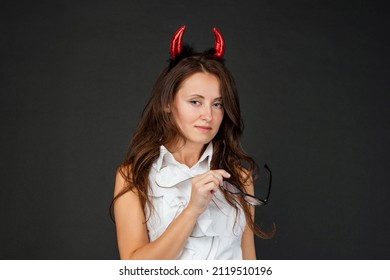 Portrait Of Serious Woman Wearing Red Devil Horns Dark Background, Halloween