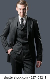 Portrait of a serious young business man, on gray background