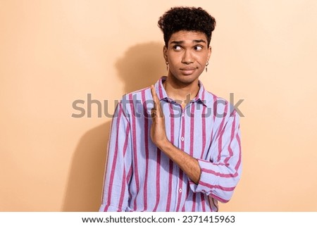 Portrait of serious young guy hold hand palm straight to empty space express negative attitude isolated beige color background