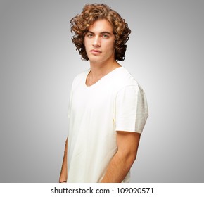 Portrait Of A Serious Young Man Standing On Grey Background