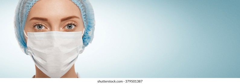 Portrait Of Serious Young Woman Doctor With Mask And Cap