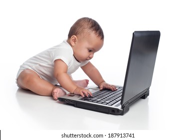 A portrait of a seven month old, Hispanic baby boy typing on a laptop computer. He is wearing a onesy. Shot in the studio and isolated on white.