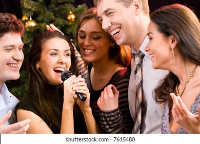 Portrait of several people singing a song together at a karaoke party - Powered by Shutterstock