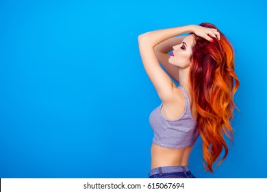 Portrait of sexual  charming stylish girl with long ginger fair hair touching head, dreaming and relaxing