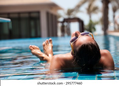 Portrait Of Sexy Cheerful Woman Relaxing At The Luxury Poolside.  Girl At Travel Spa Resort Pool. Summer Luxury Vacation. 