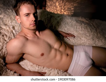 Portrait Of Sexy Eastern European Man In His Briefs Lying On Bed With Muscular Sixpack Abs