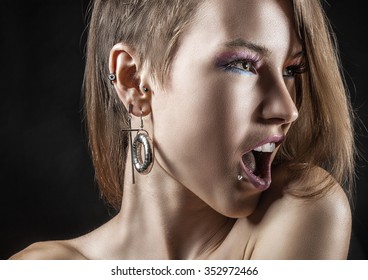 Portrait of a sexy girl with piercings on a black background