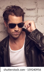 Portrait Of Sexy Man In Sun Glasses. Holding On Side Of The Glasses 