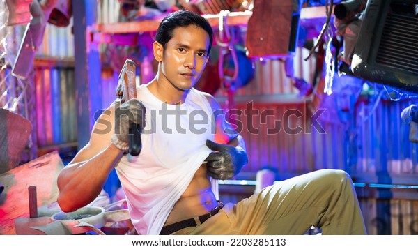 Portrait sexy model asian male mechanic\
engineering with big muscle in a Car Service. Repair service\
specialist, technical\
maintenance