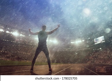 Portrait Of Sexy Muscle Man Posing On Stadium In Epic Rain