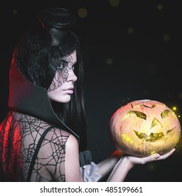 Portrait of sexy woman with gothic makeup smokey eyes. Holding a pumpkin. Vampire, evil. Goth. Horror. Secret. Fashion. Venetian carnival. Hot babe. Halloween party masquerade - Shutterstock ID 485199661