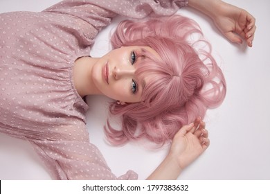 Portrait of a sexy young woman with pink hair. Perfect hairstyle and hair coloring. Girl with beautiful blue eyes and long pink hair
