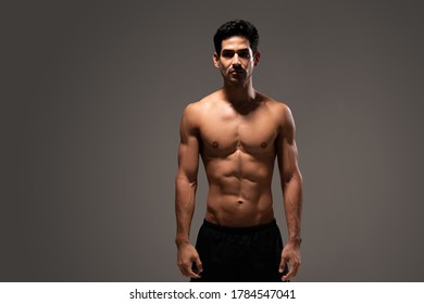 Portrait Of Shirtless Hispanic Male Athlete With Muscular Body Standing In Studio