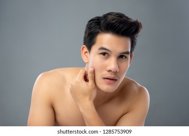 Portrait Of Shirtless Young Handsome Asian Man Touching And Checking His Face For Skin Care And Beauty Concepts Studio Shot