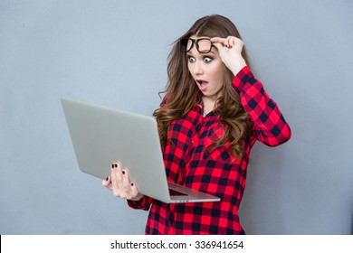 Portrait Of Shocked Beautiful Girl In Glasses With Opened Mouth Using Laptop