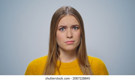 Portrait of shocked girl looking on grey background. Closeup disappointed woman posing in slow motion. Worried lady shock at camera. Upset female model standing in studio. Displeased customer user
