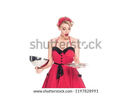 portrait of shocked pin up woman looking at empty serving tray in hands isolated on white