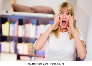 Portrait Of Shocked Woman Against A Book Shelf