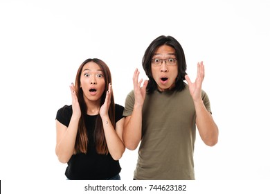 Portrait Of A Shocked Young Asian Couple Holding Face At Their Face Isolated Over White Background