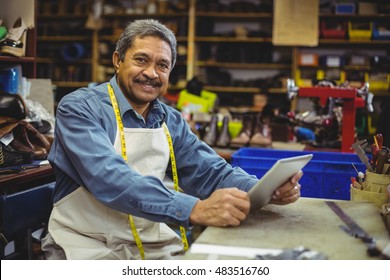 Portrait of shoemaker using digital tablet in workshop - Powered by Shutterstock