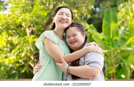 Portrait shot of Asian mother and young cute girl with braid pigtail hairstyle stand hugging cuddling embracing together with love smiling look at camera