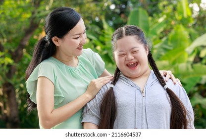 Portrait shot of Asian mother and young cute girl with braid pigtail hairstyle stand hugging cuddling embracing together with love smiling look at camera
